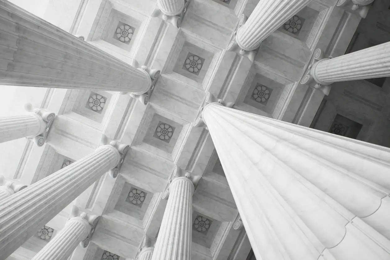 Upward view of classic architectural columns with ornate ceilings.
